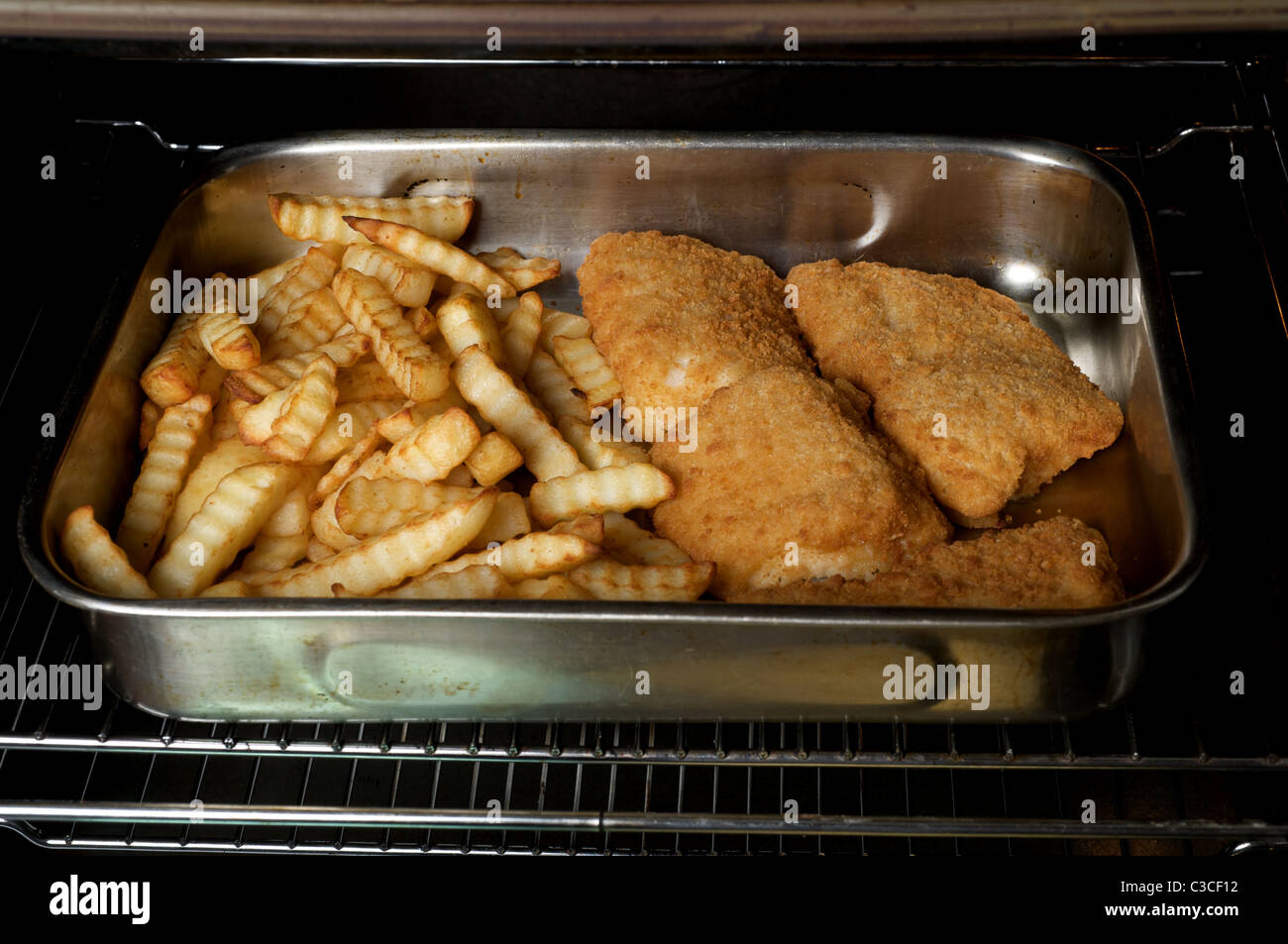 Frozen fish and chips baked in an oven Stock Photo Alamy