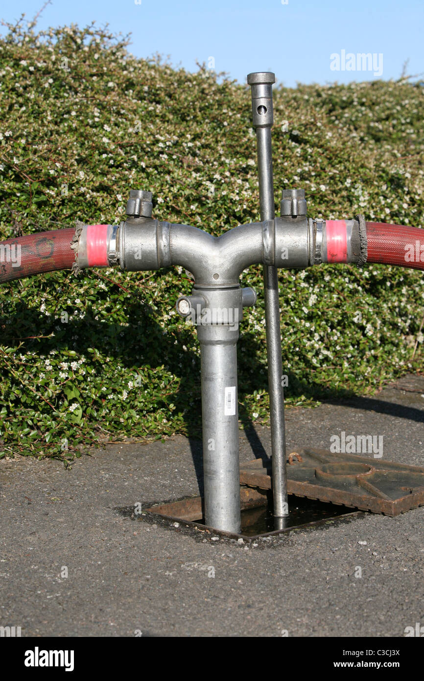 hoses tapping into the underground water supply to fight a fire Stock Photo