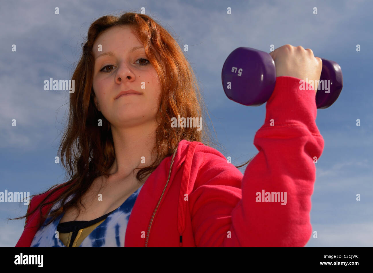 Teenage girl exercising by pumping 5 pound hand weights Stock Photo Alamy