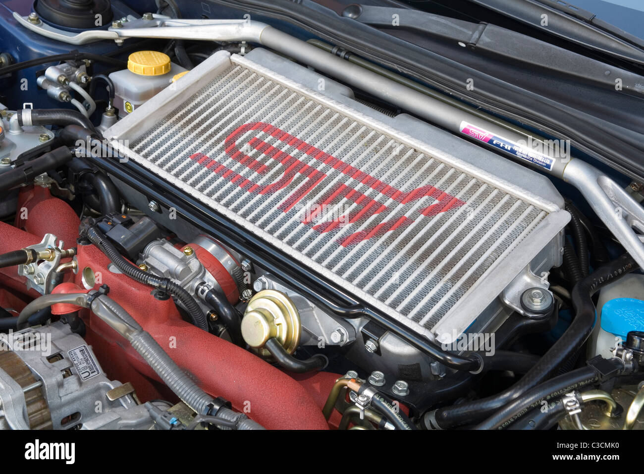 Turbocharger intercooler on top of the engine in a Subaru STi Imprezza Japanese sports car. Stock Photo