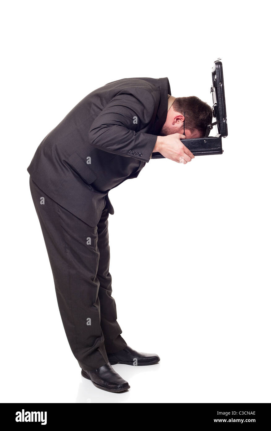 A businessman buries his head in his briefcase like an Ostrich. Stock Photo