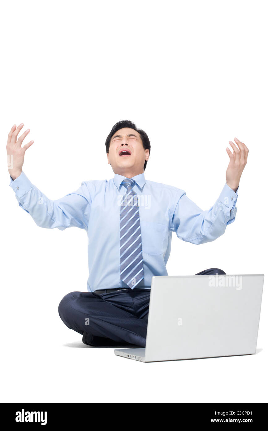 A frustrated businessman sitting on the floor with his laptop Stock ...
