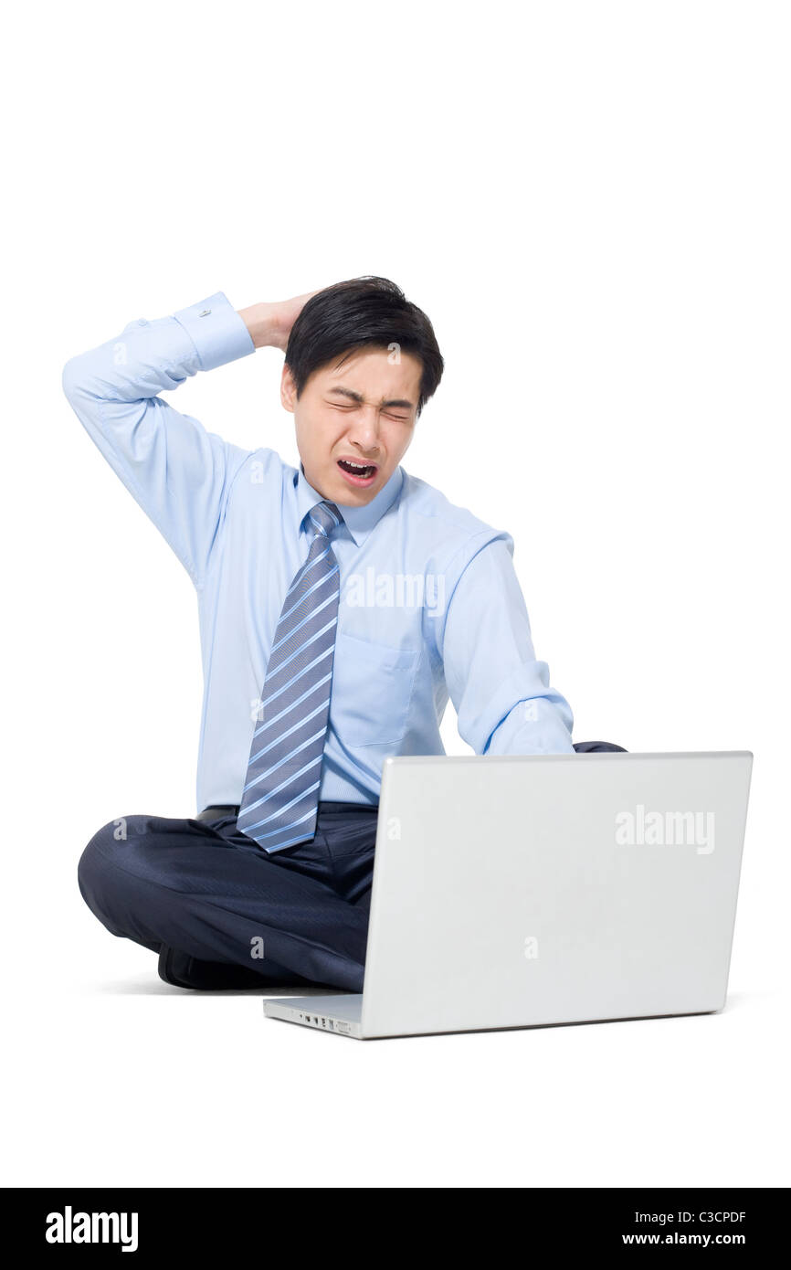 A frustrated businessman sitting on the floor with his laptop Stock ...
