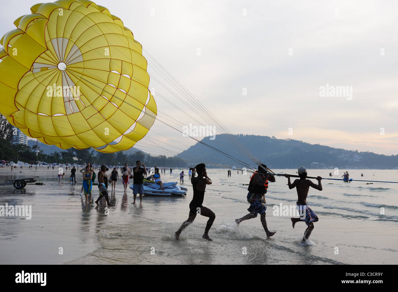 Unidentified man (in the middle) parasails at sunset on FEB 6,2011 at Patong Beach, Phuket, Thailand Stock Photo
