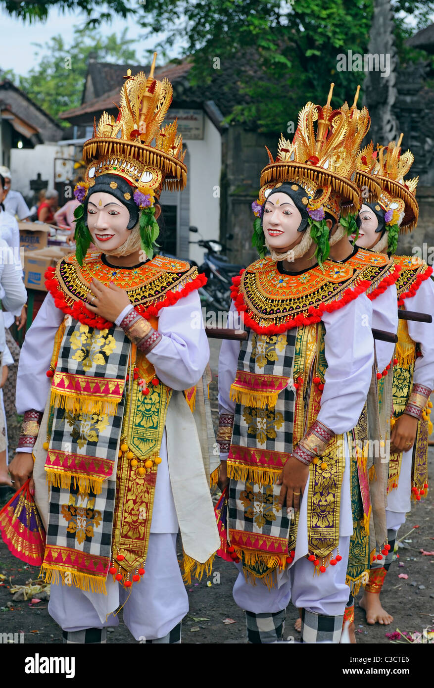balinese dancers in colorful costumes and masks during a religious ceremony Stock Photo
