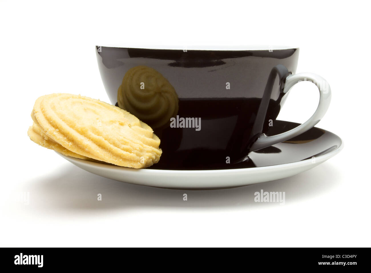Viennese Swirl Biscuits resting on cup and saucer tea break concept. Stock Photo