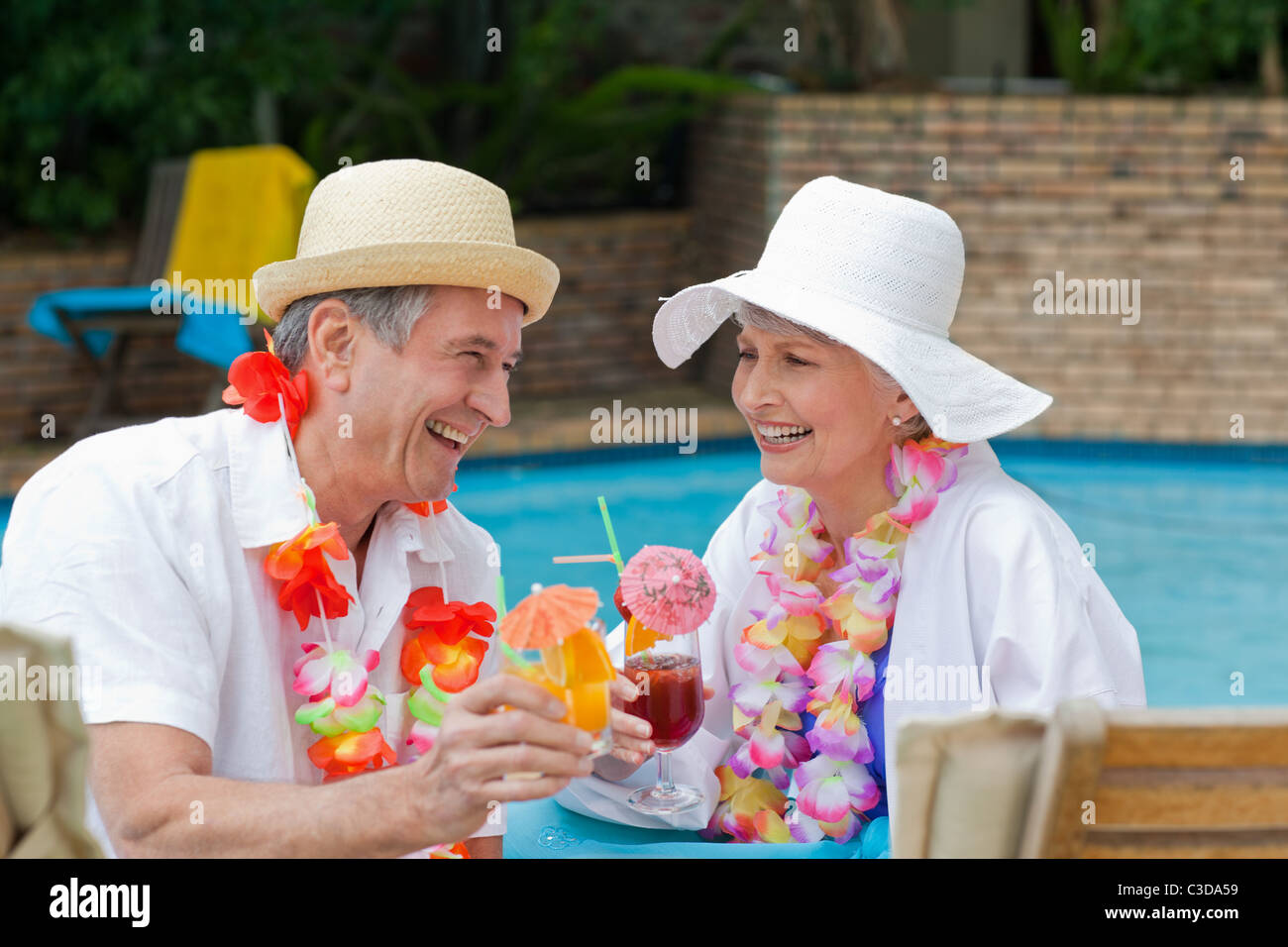Happy senior couple drinking cocktails and toasting each other Stock Photo