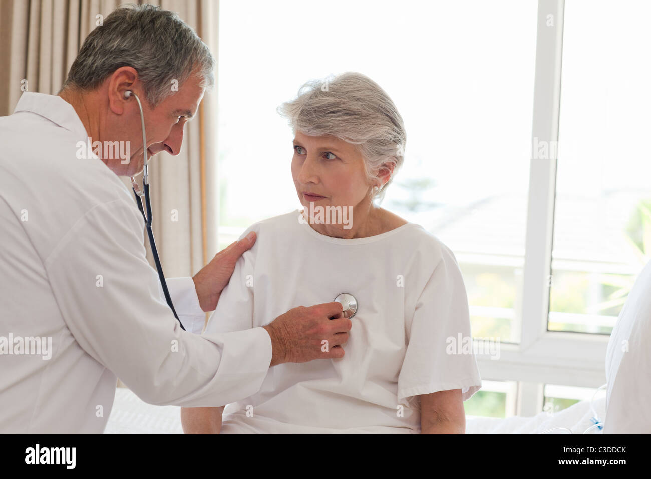 Senior doctor taking the heartbeat of his patient Stock Photo - Alamy