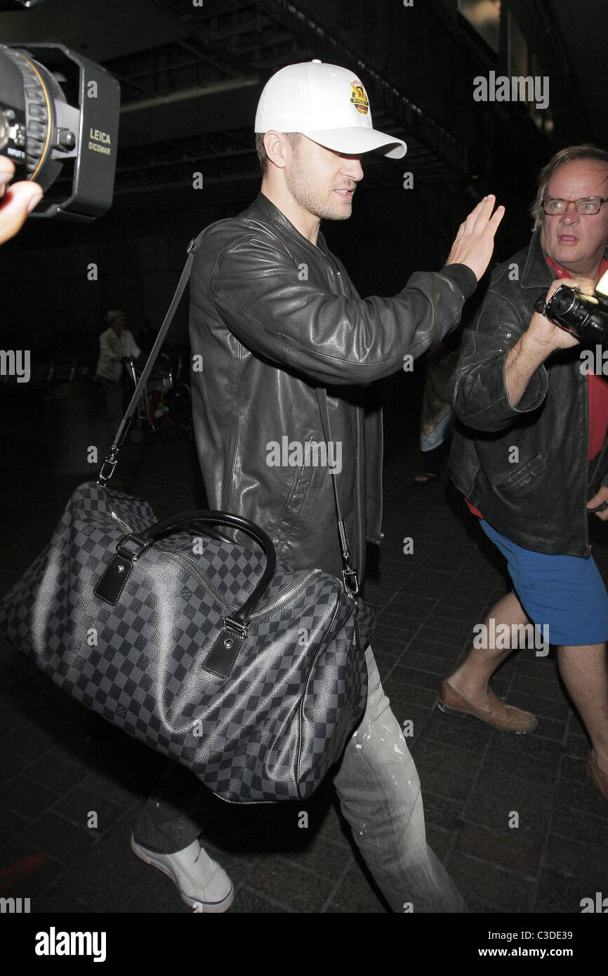 Justin Timberlake carrying his matching Louis Vuitton luggage as