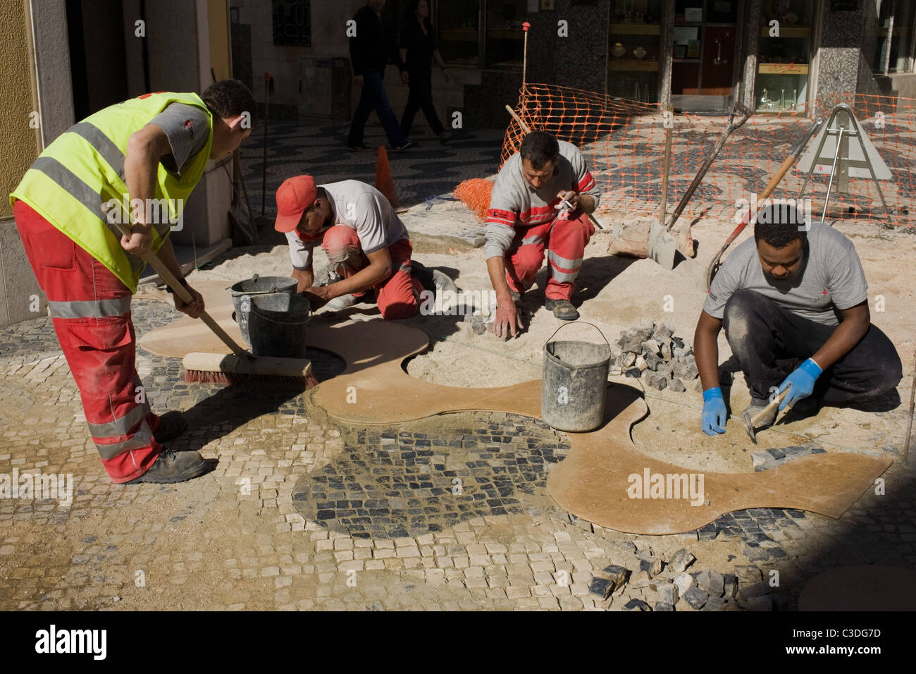 Workers repairing calcadas in Cascais, Portugal Stock Photo