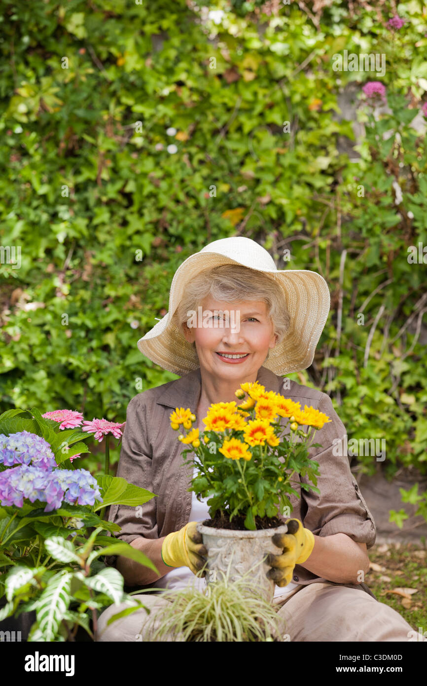 Retired woman working in the garden Stock Photo - Alamy