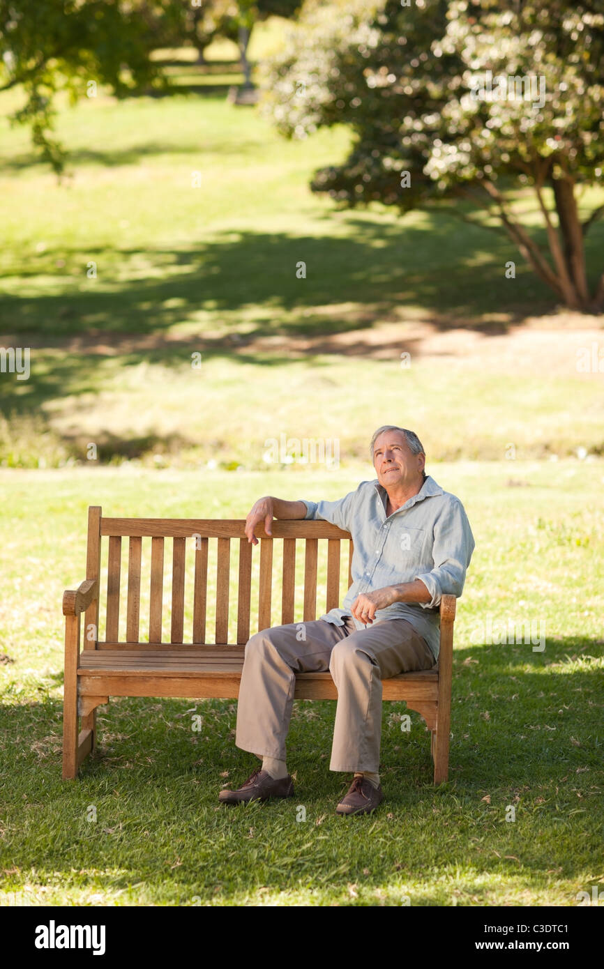Elderly man sitting on a bench Stock Photo - Alamy