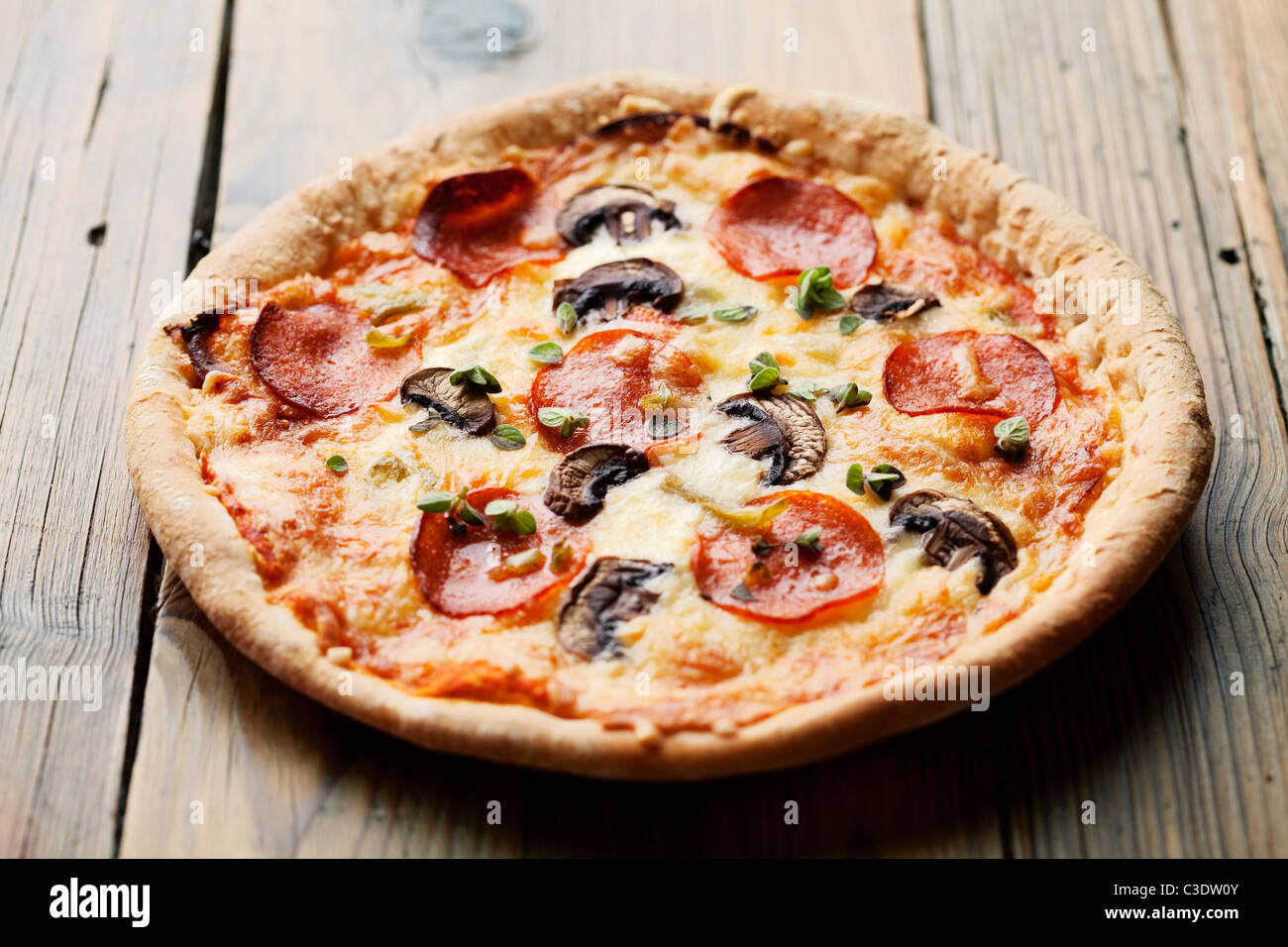 pepperoni and mushrooom pizza on rustic table Stock Photo
