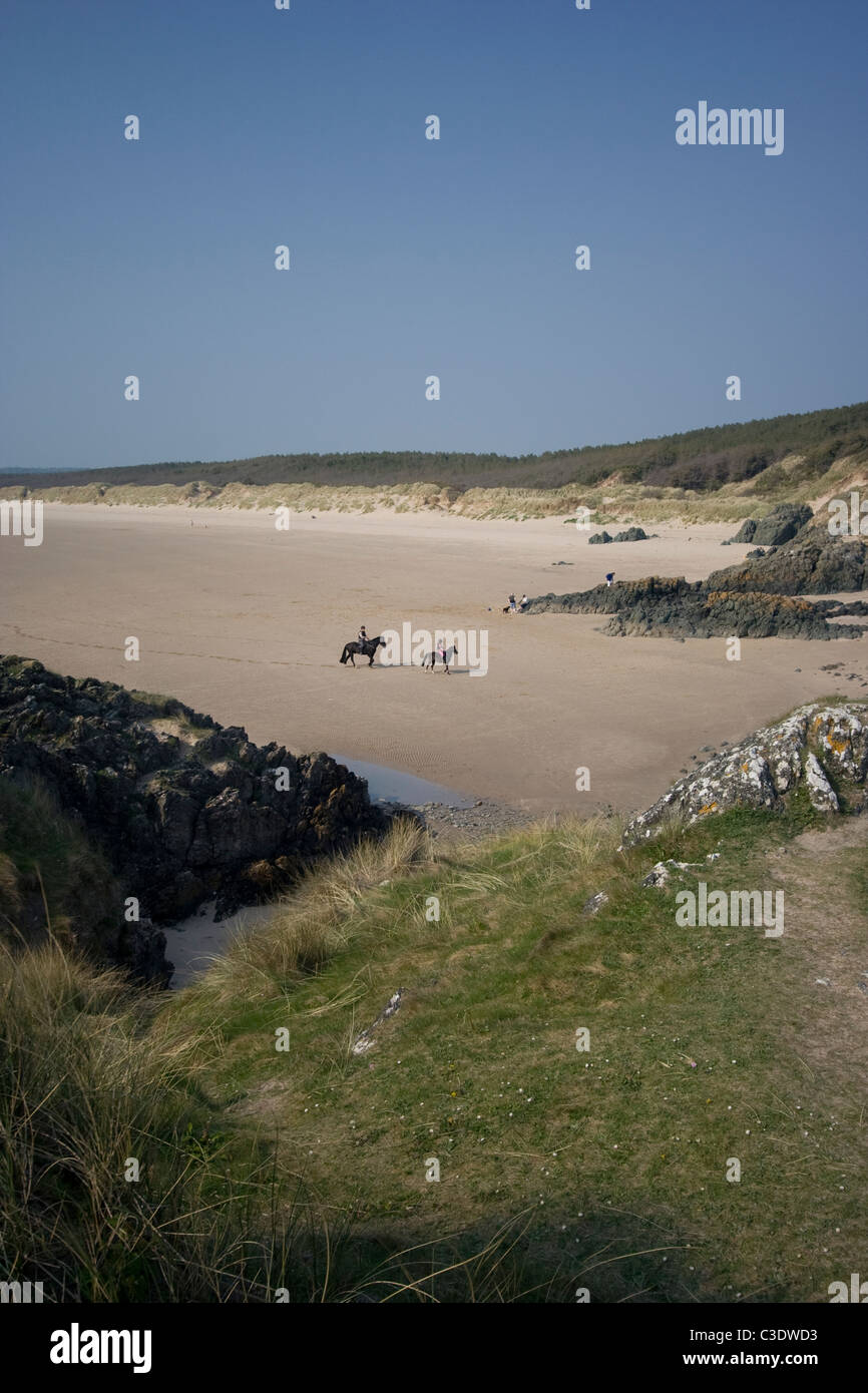 Horse riding on Llanddwyn Island beach, Anglesey Stock Photo