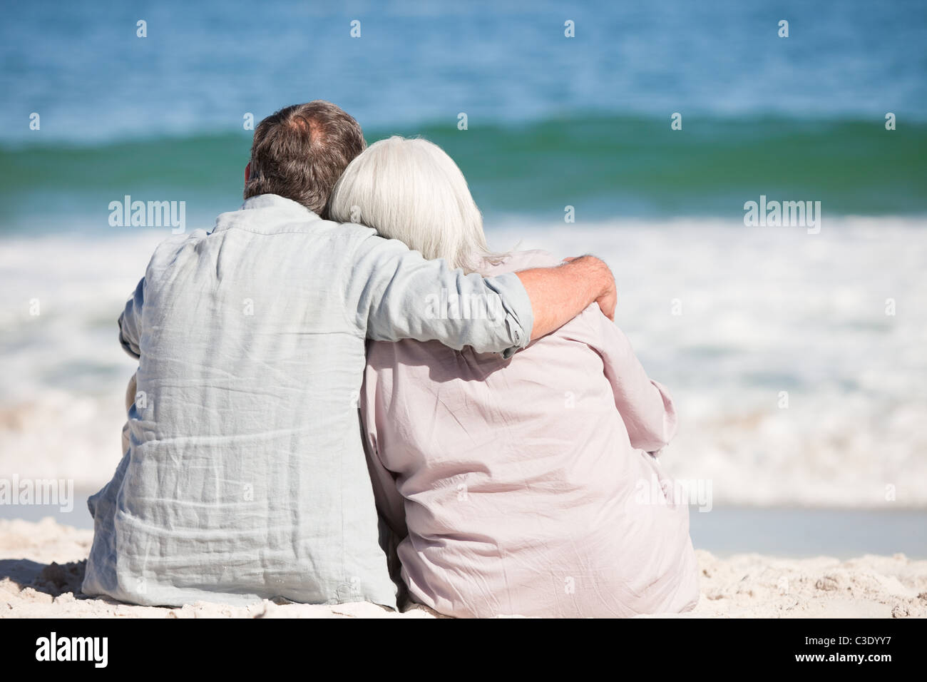 Senior couple sitting on the beach Stock Photo - Alamy