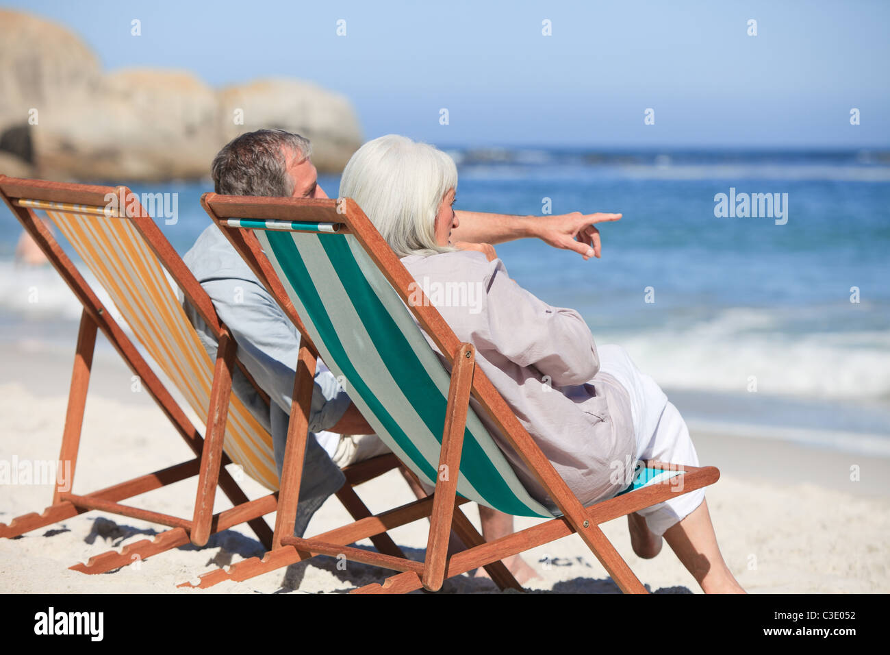 Retired couple sitting on deck chairs Stock Photo - Alamy