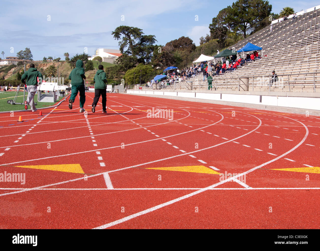 Athletes running laps on a newly painted race track Stock Photo Alamy