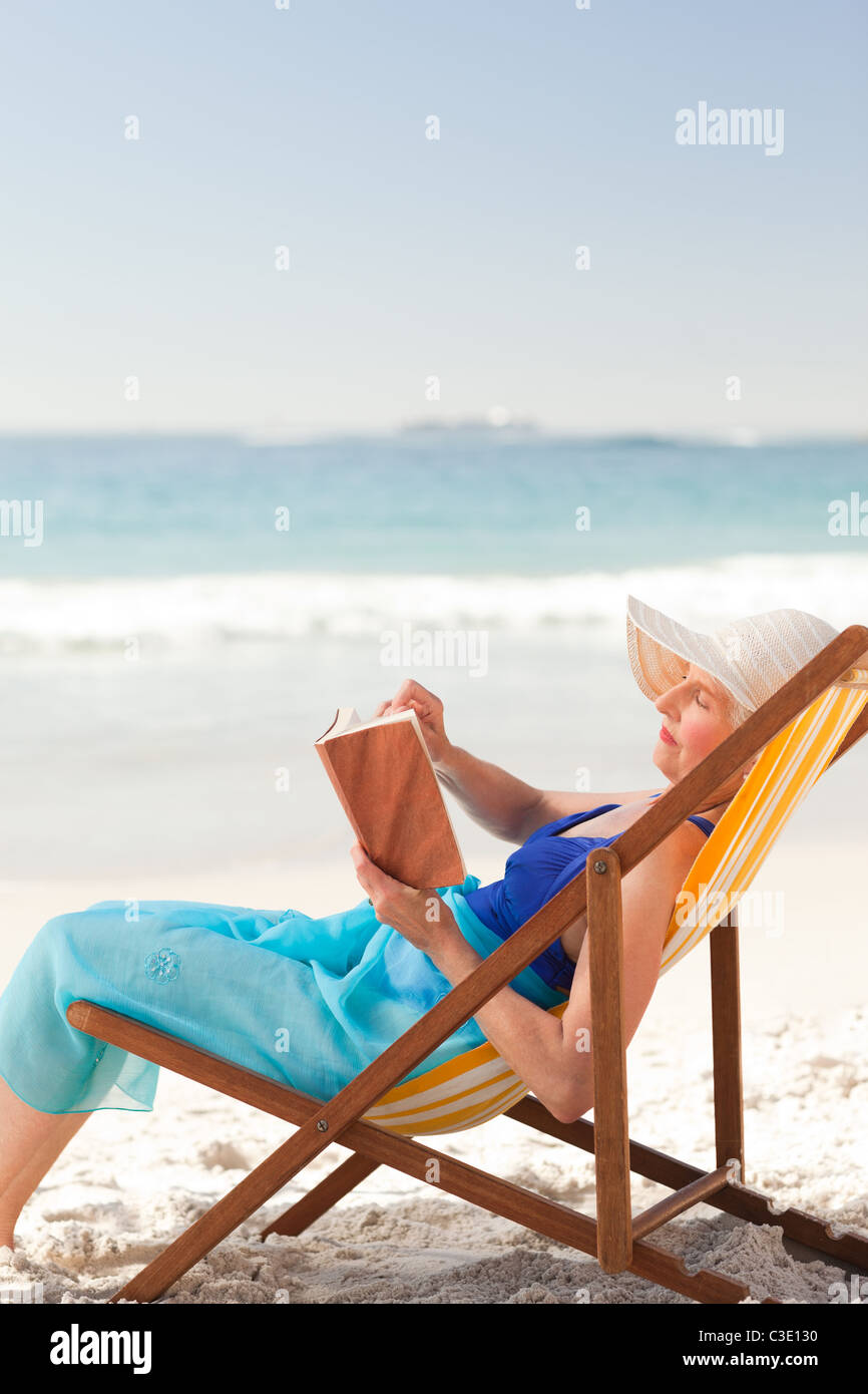 Elderly woman reading a book at the beach Stock Photo - Alamy