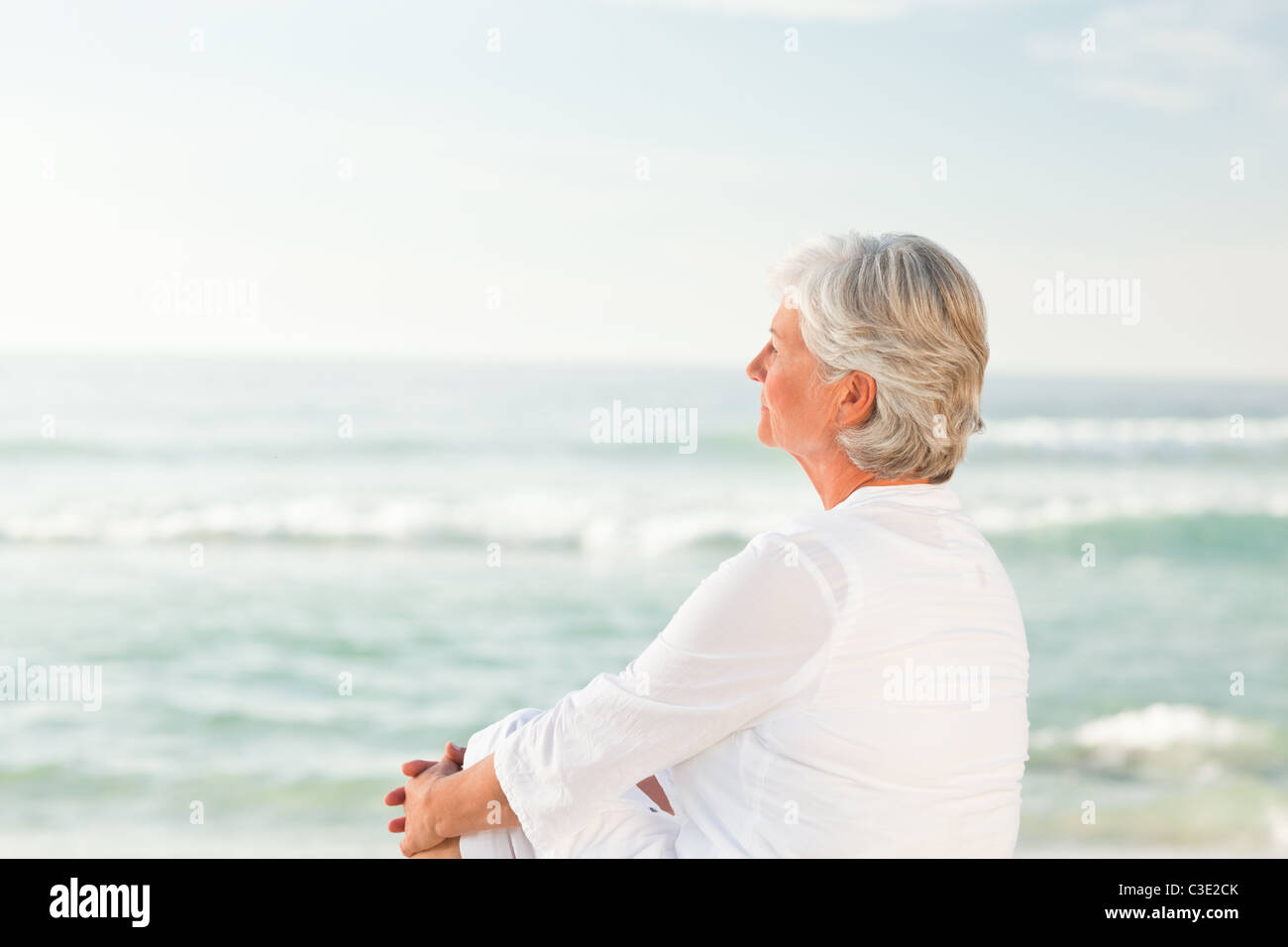Woman who is sitting on the beach Stock Photo - Alamy