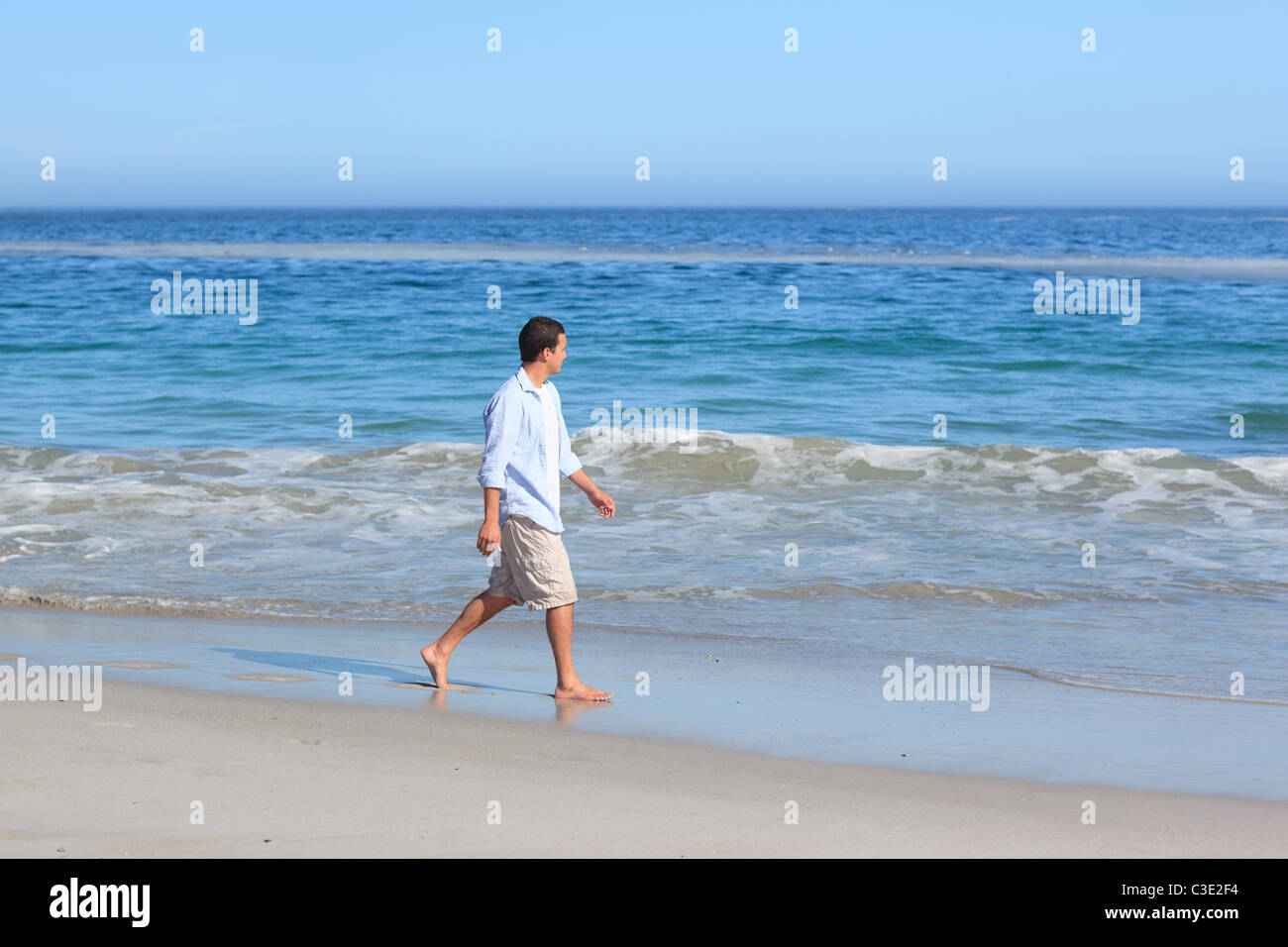 Man walking on the beach Stock Photo - Alamy