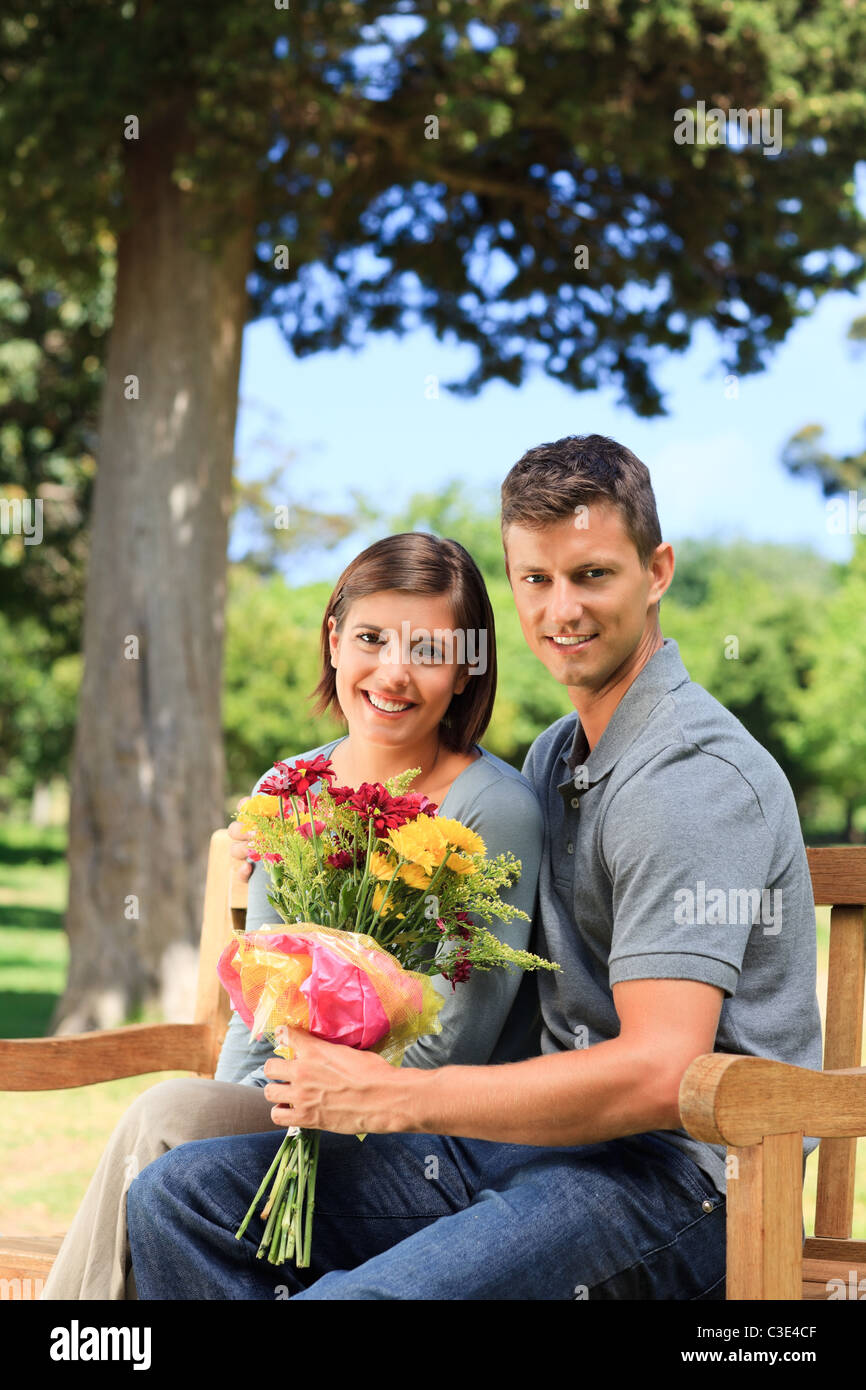 Young man offering flowers to his girlfriend Stock Photo