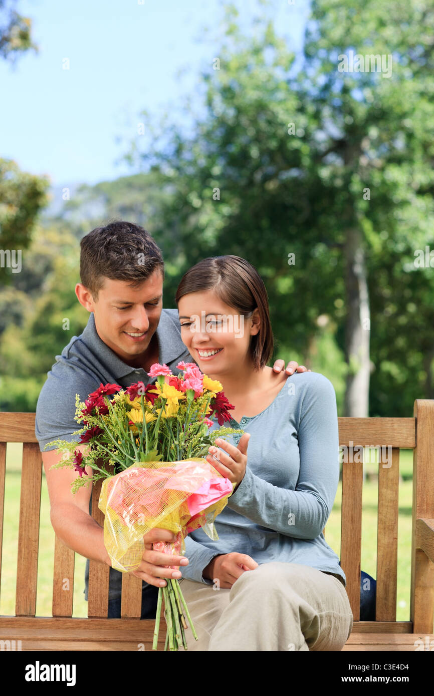Young man offering flowers to his girlfriend Stock Photo