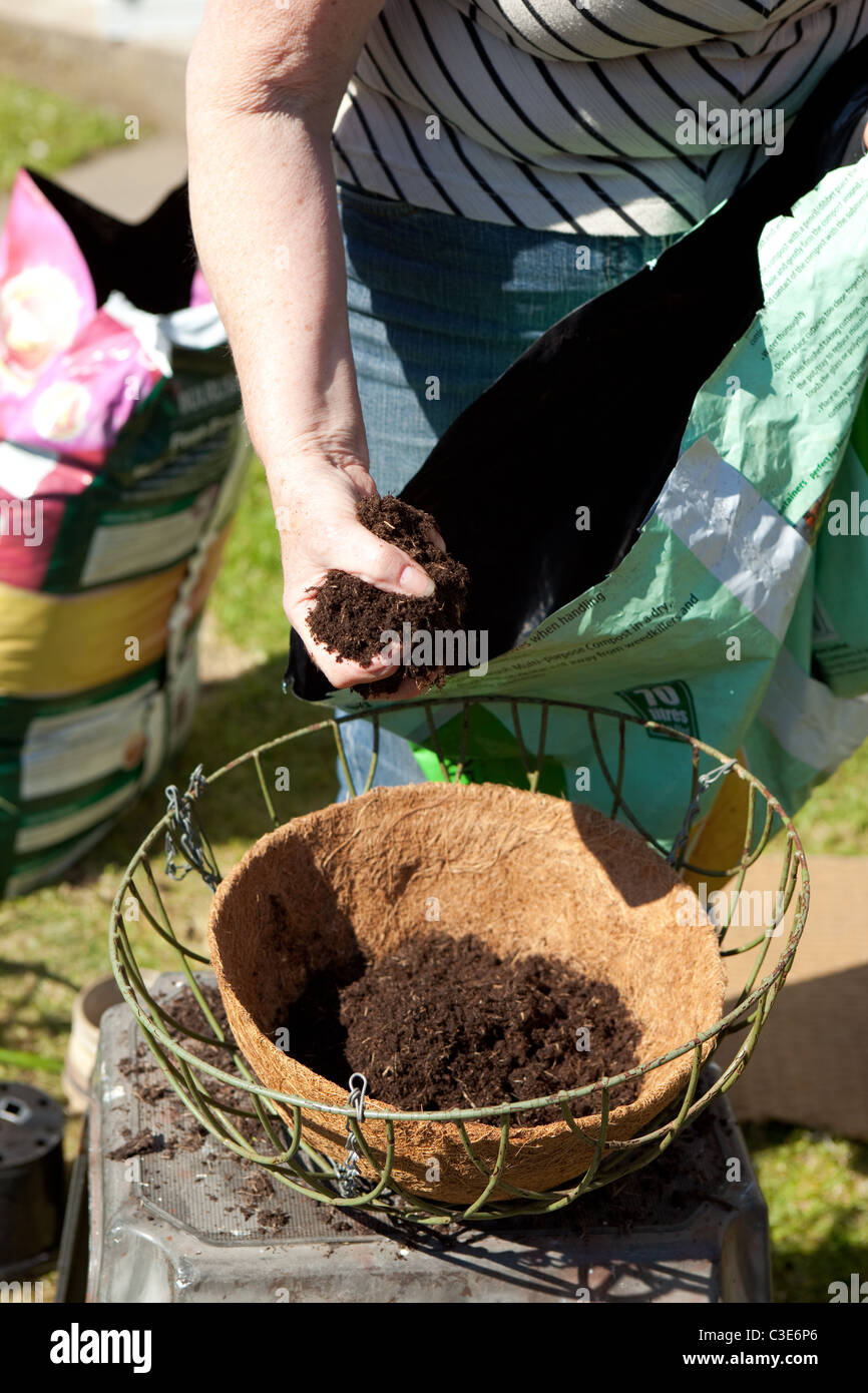 Filling hanging basket with fresh compost gardening instructional image Stock Photo
