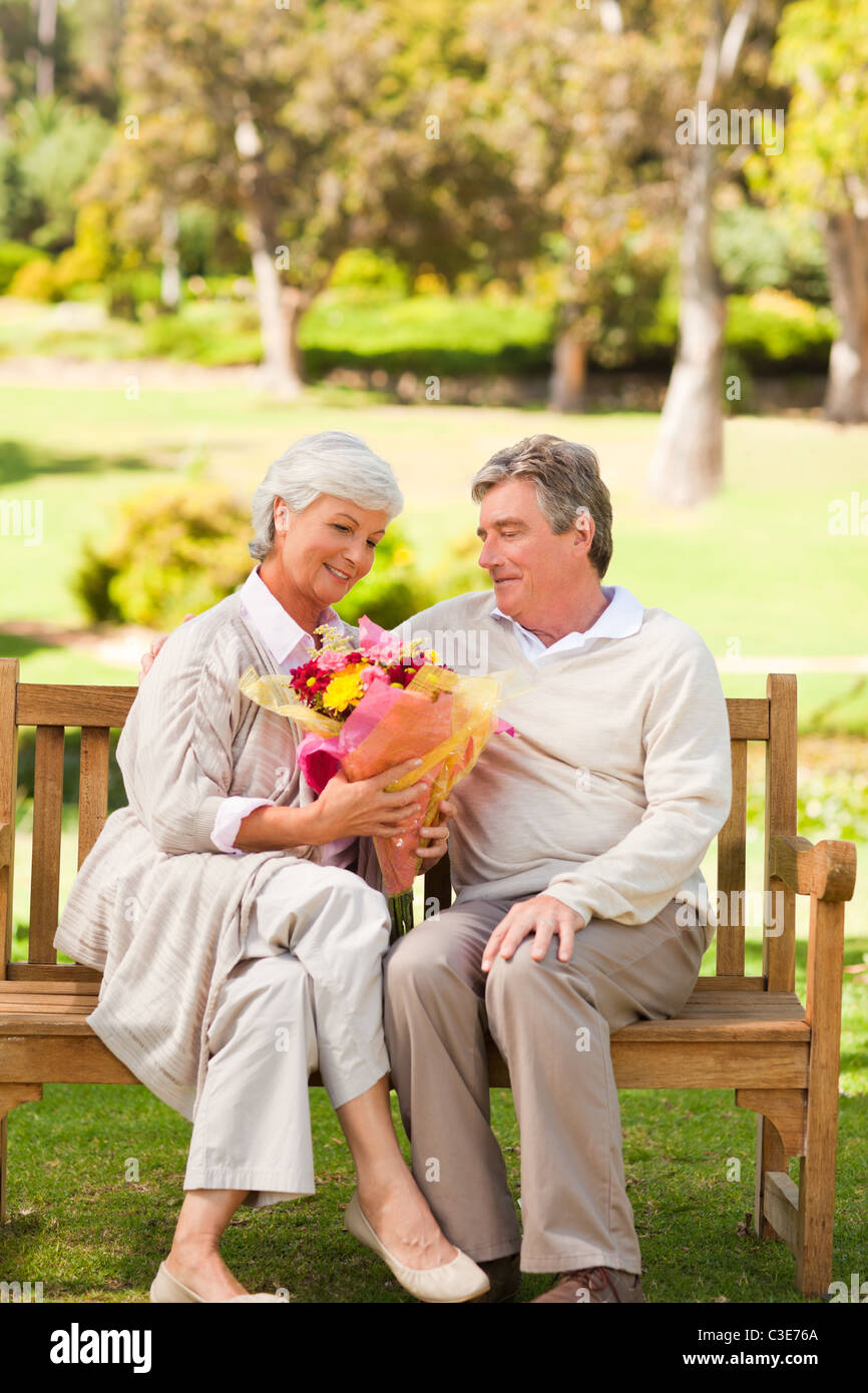 Senior man offering flowers to his wife Stock Photo