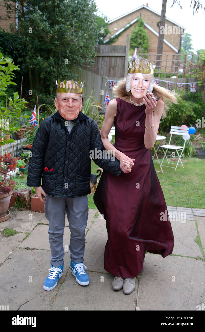 Royal wedding street party celebrations in a London garden with the guests wearing Royal masks Stock Photo