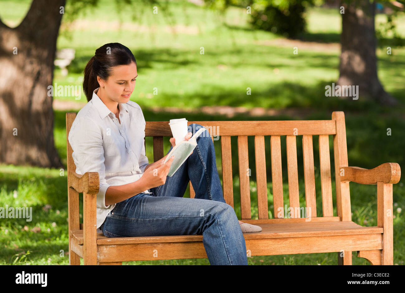 Young woman reading on the bench Stock Photo - Alamy