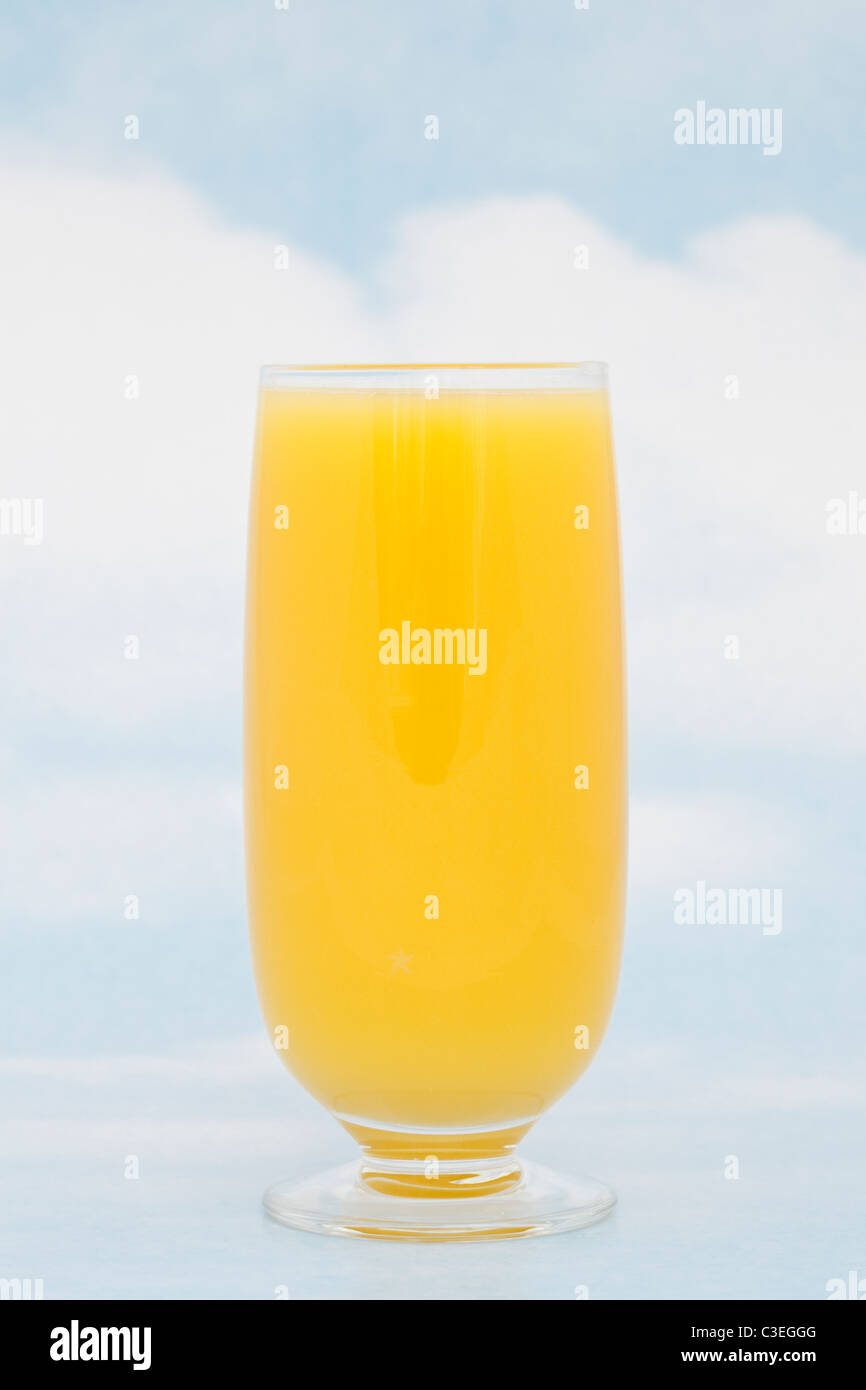 A glass of fresh orange juice containing vitamin C against blue sky background Stock Photo Alamy