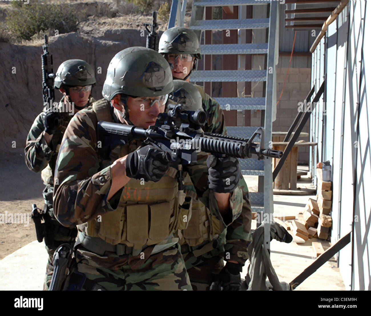 A team of four SEAL trainees prepare to breach a room during a SEAL qualification training exercise. Stock Photo