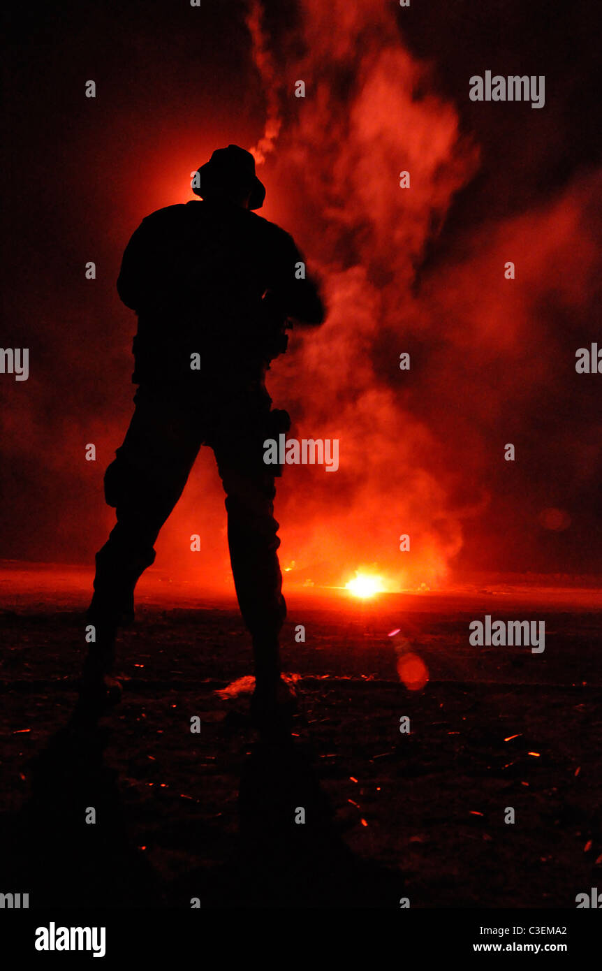 US Navy SEAL team member is illuminated by a flare during a night training exercise on San Clemente Island. Stock Photo