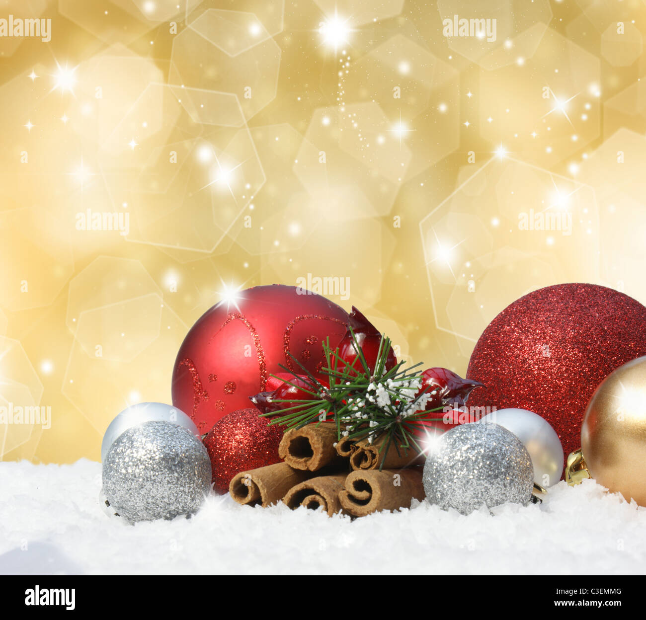 Christmas baubles in snow on gold background Stock Photo - Alamy