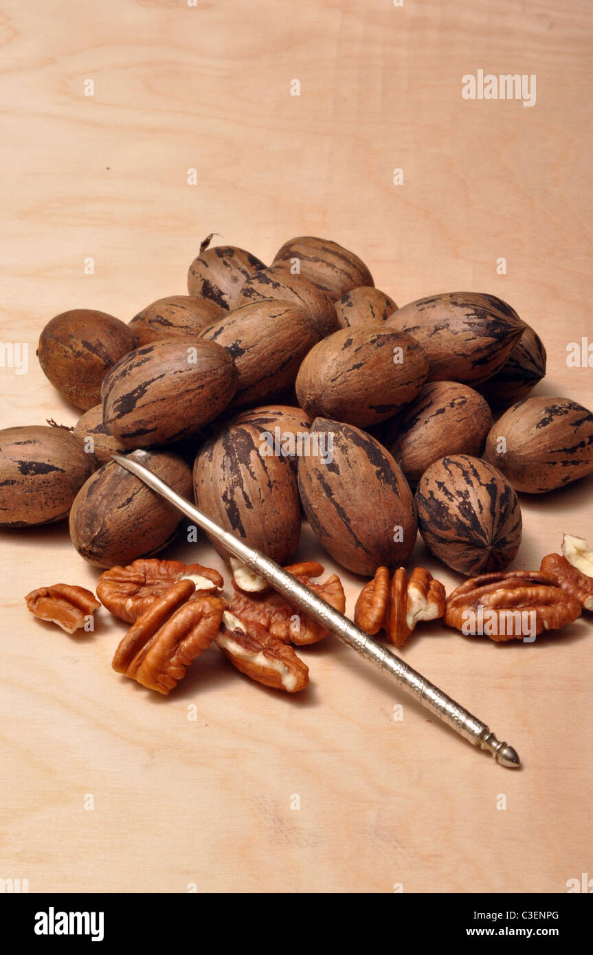 Shelled and unshelled pecans on a brown table top. Stock Photo