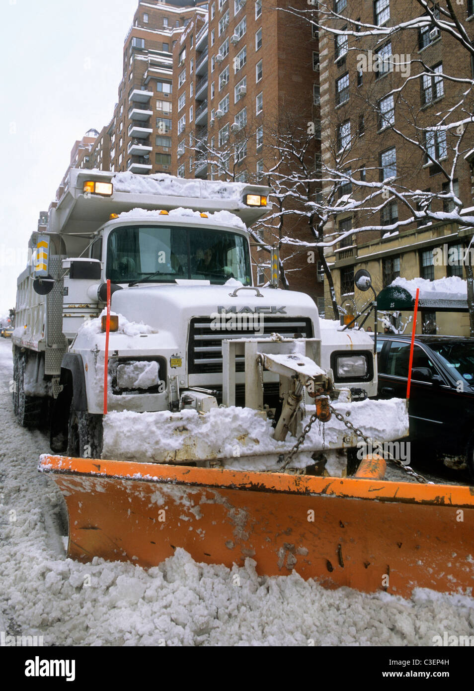 Snow plow vehicle clearing street after a winter snowstorm in New York City. Snow removal by sanitation department truck. Clearing a road. USA Stock Photo