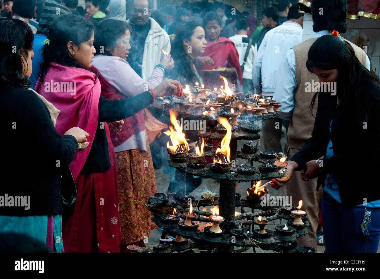 Worshippers light candles at a Kathmandu temple, Nepal Stock Photo