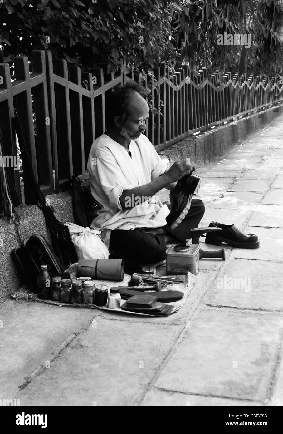 Shoemaker on footpath, New Delhi, India Stock Photo