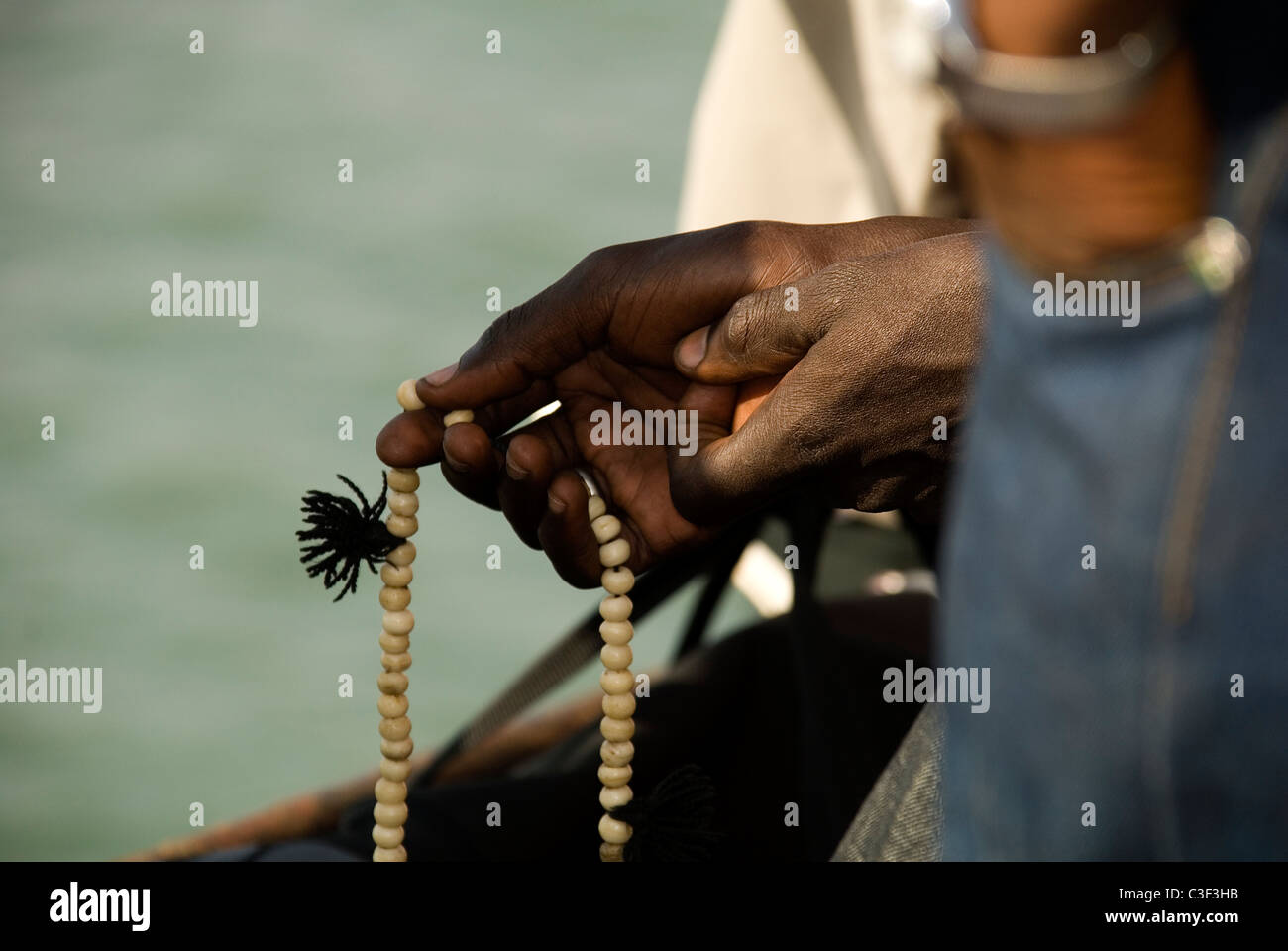 A Muslim counting his prayer beads on the ferry crossing from Banjul to