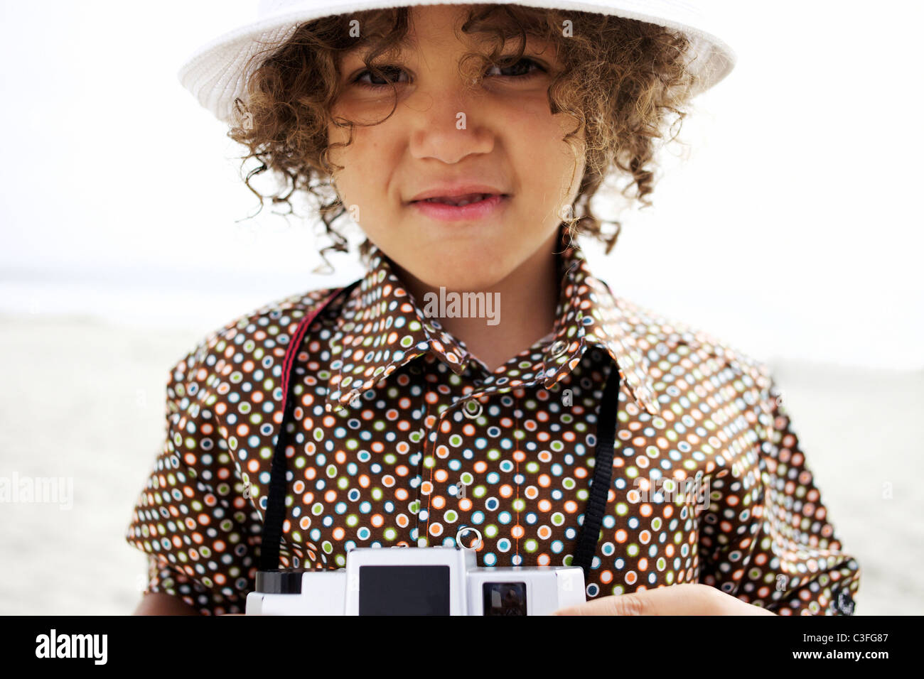 Mixed race boy using old-fashioned camera Stock Photo
