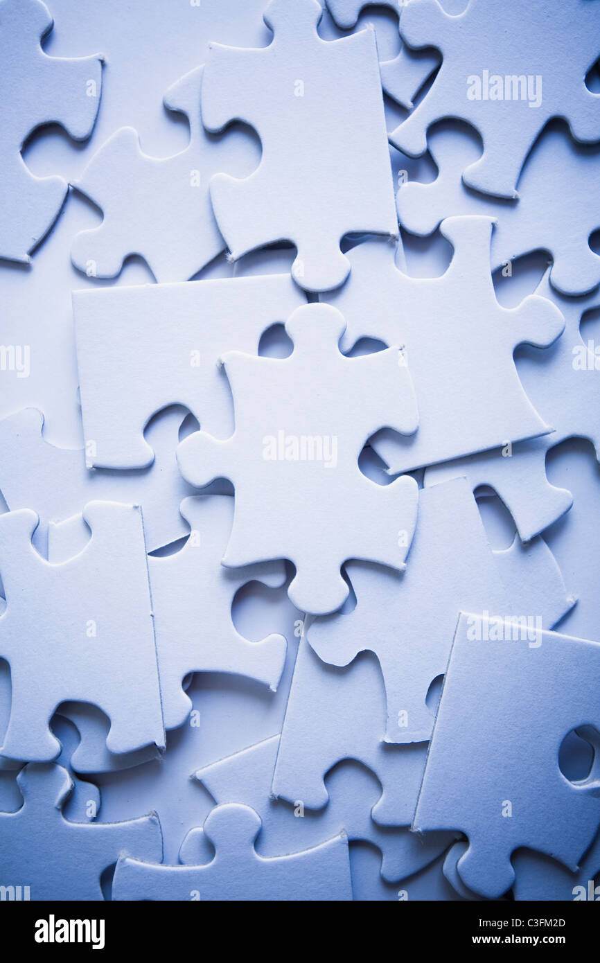 Randomly arranged jigsaw puzzle pieces with the focus subtly on one piece. Stock Photo