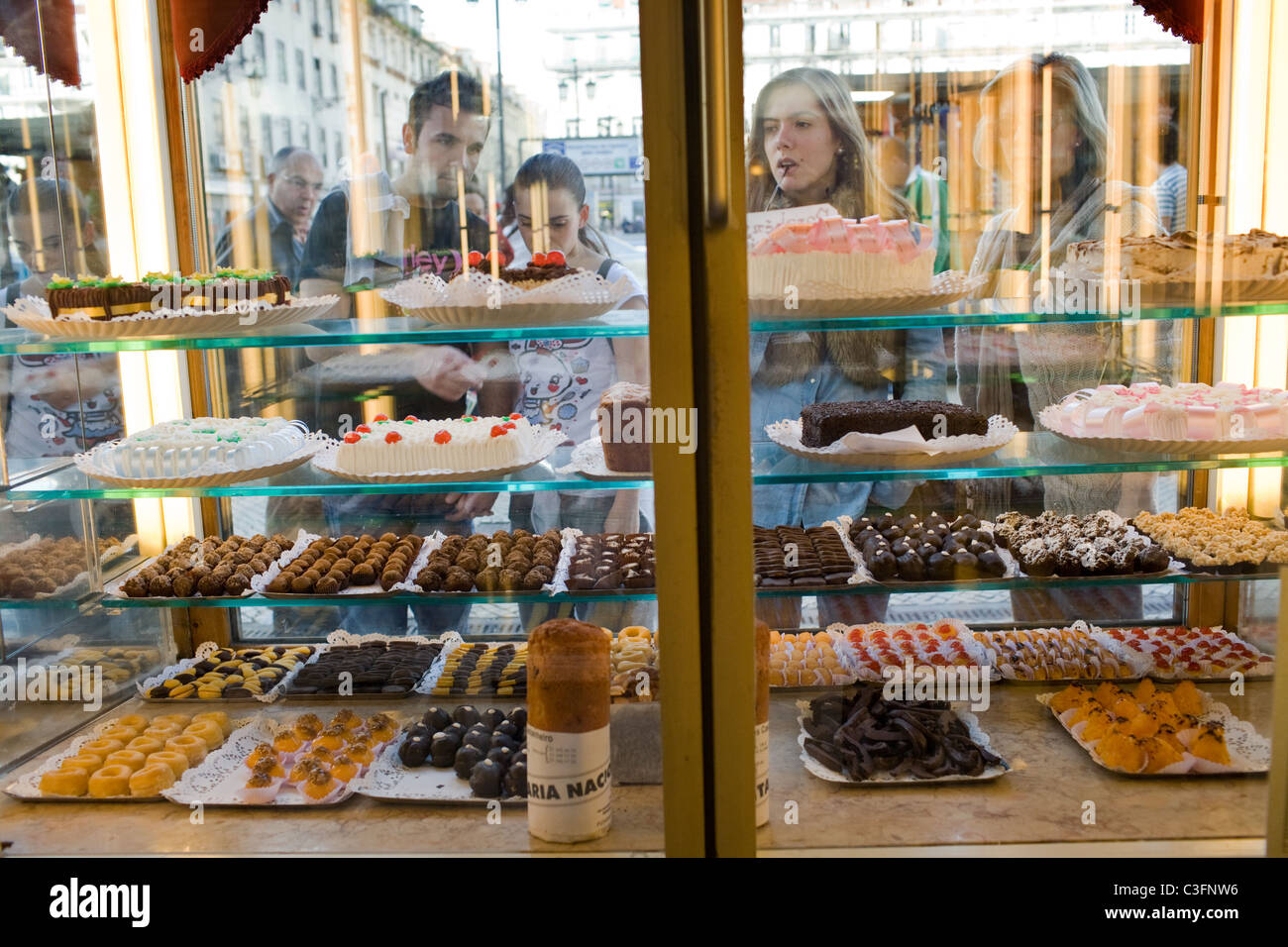 Women inspect dessert display in window of Confeitaria Nacional, Baixa, Lisbon, Portugal Stock Photo
