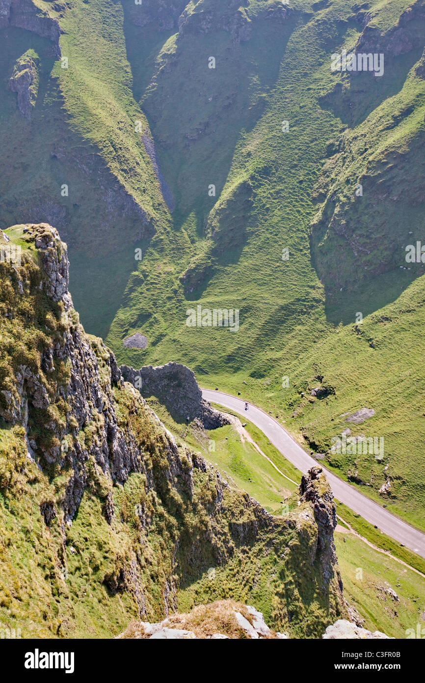 A lone cyclist speeds down the steep limestone gorge of Winnat's Pass ...