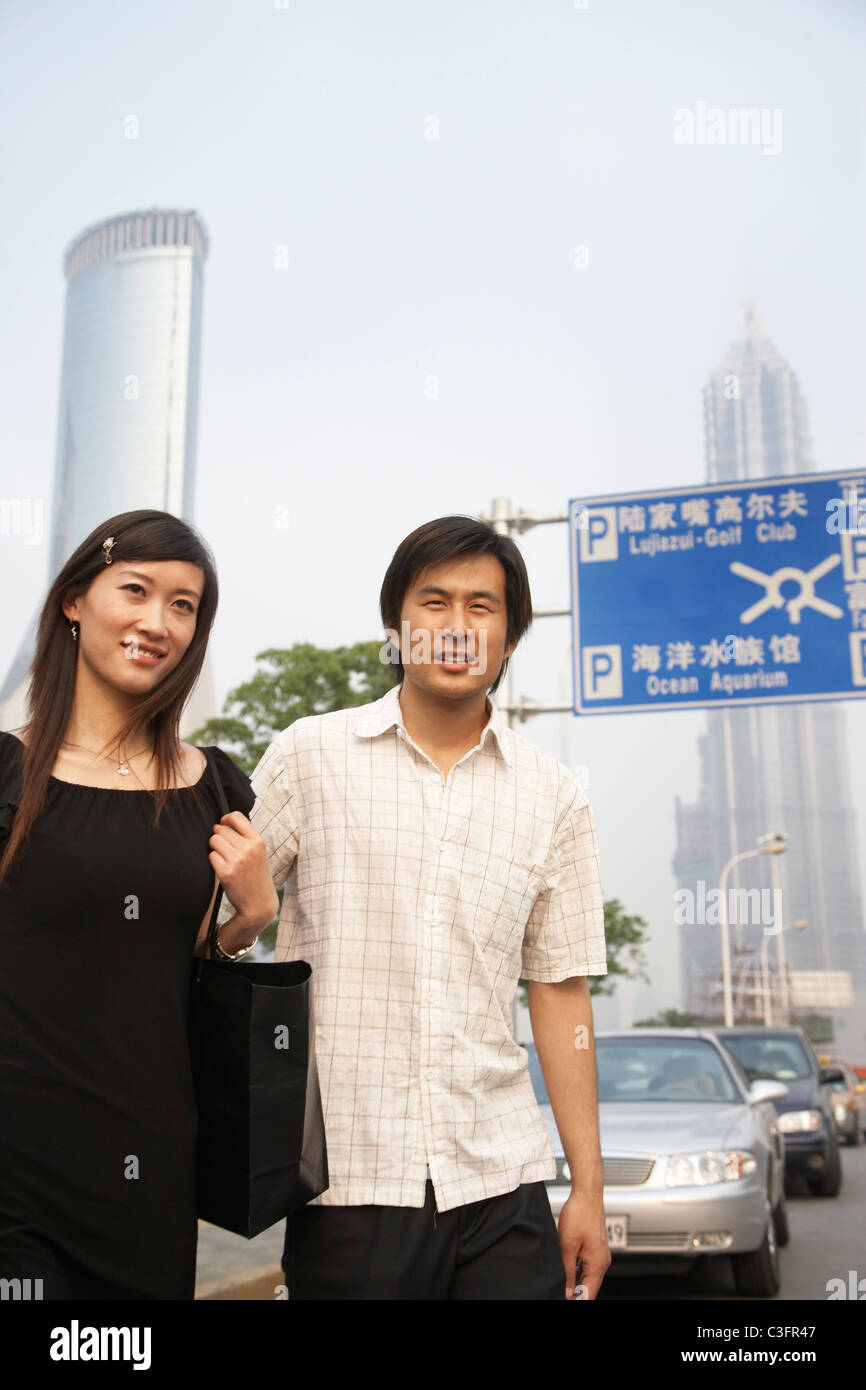 Chinese couple walking in urban area Stock Photo