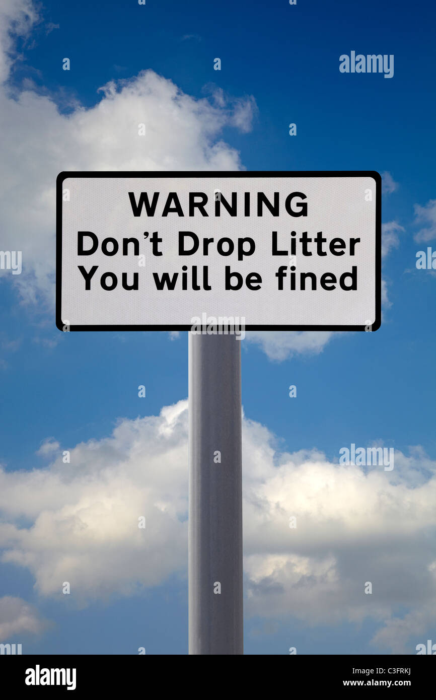 Don't drop litter sign in England. Cut out against a Blue sky with white clouds. Stock Photo