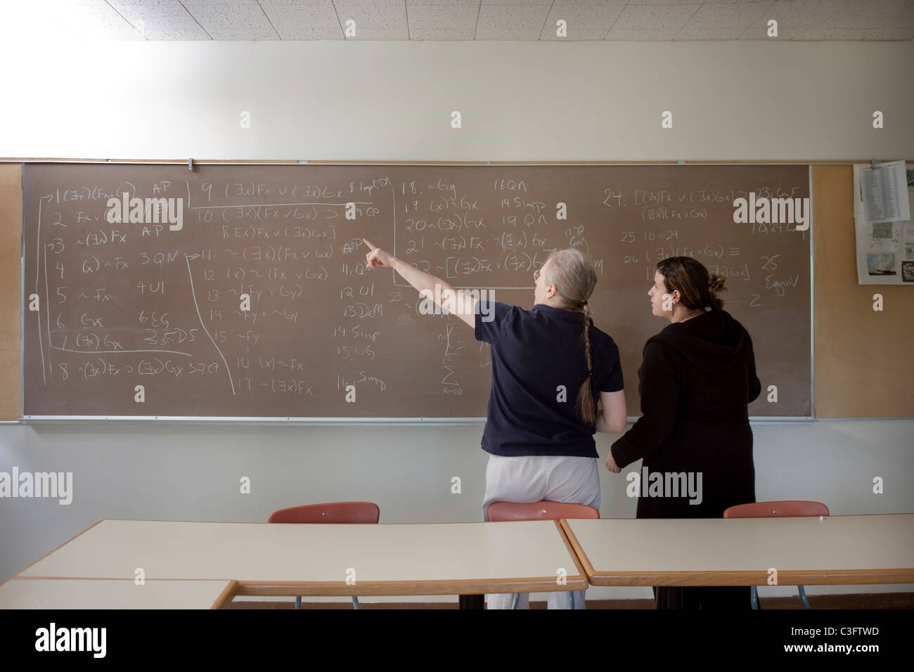Teacher explaining arithmetic to student in classroom Stock Photo - Alamy