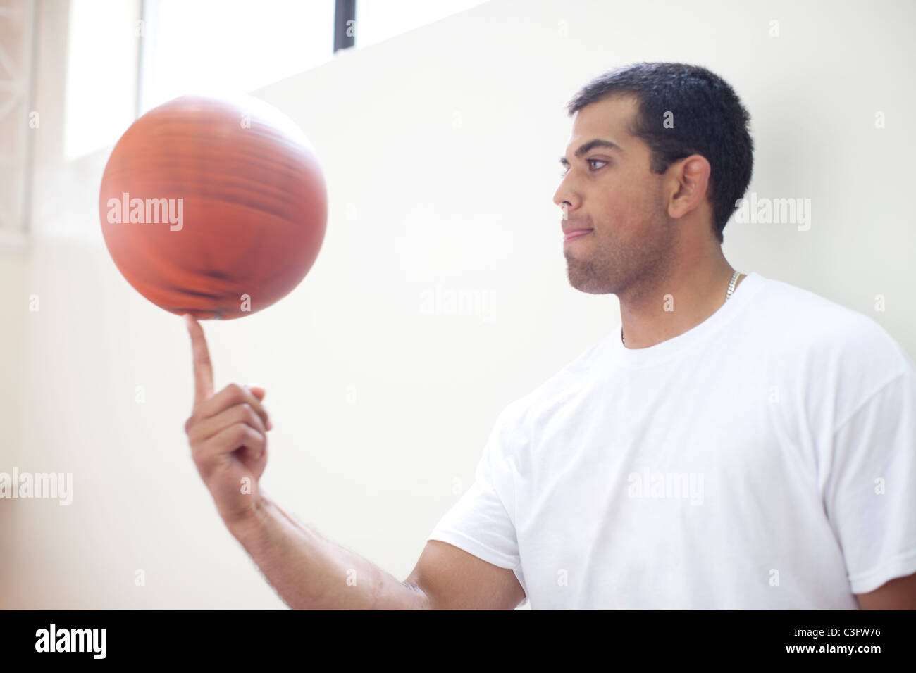 Hispanic Man Spinning Basketball On Finger Stock Photo Alamy