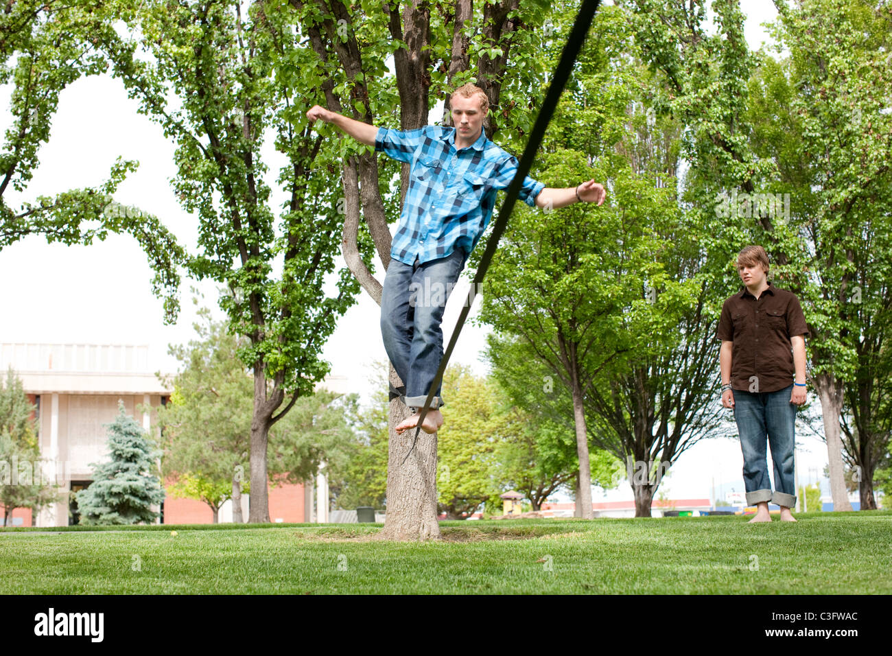 Caucasian man balancing on rope in park Stock Photo
