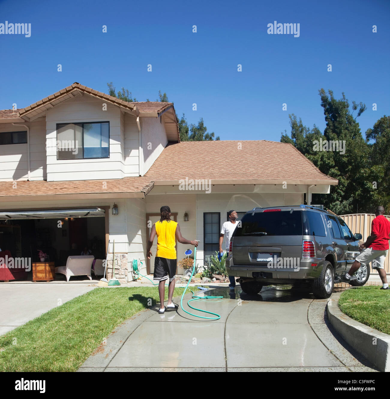 Black family washing car in driveway Stock Photo Alamy