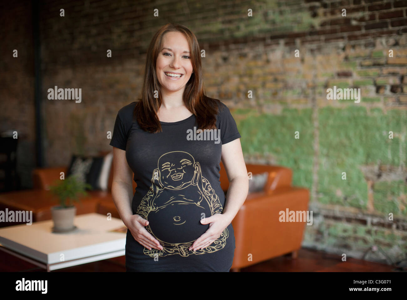 Smiling pregnant Caucasian woman holding stomach Stock Photo - Alamy